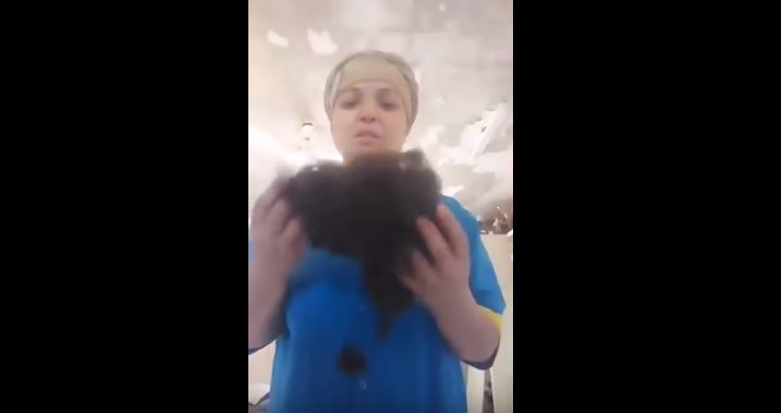 Нурбиби Мансурова показывает в видеообращении свои волосы, которые у нее насильно состригли работодатели